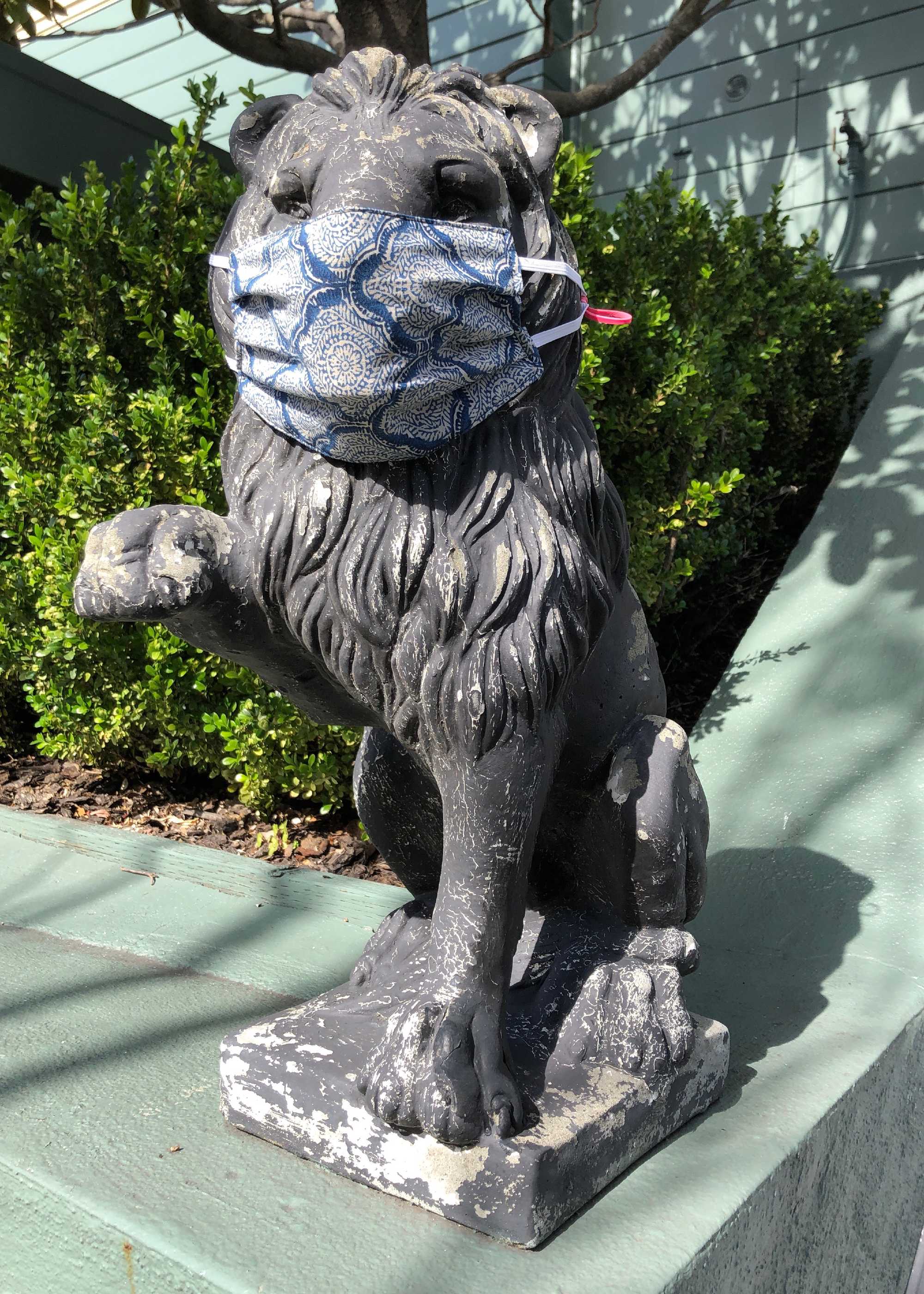 Sign of the times: A stone lion wearing a mask