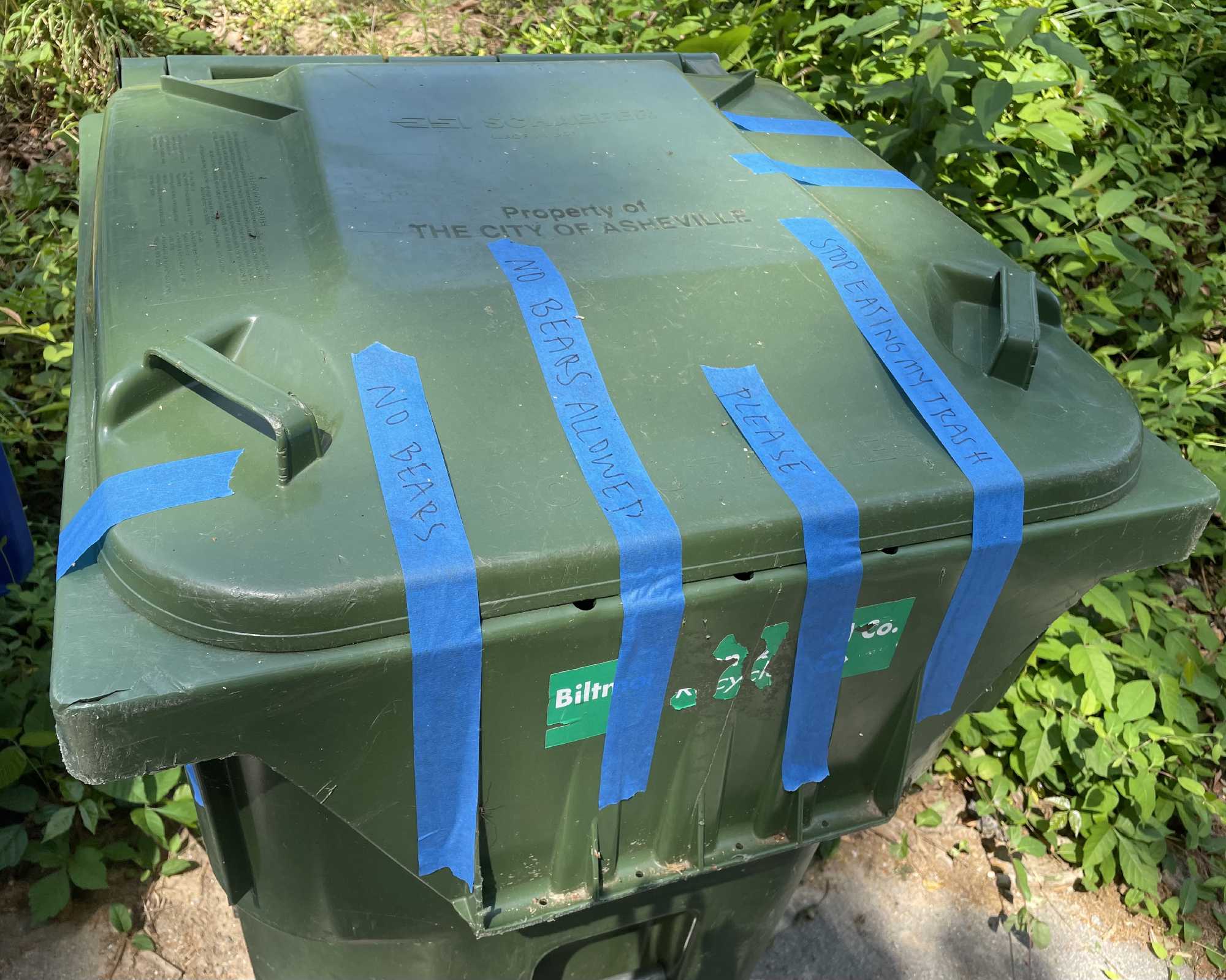 A trash can is bear proofed with painters tape